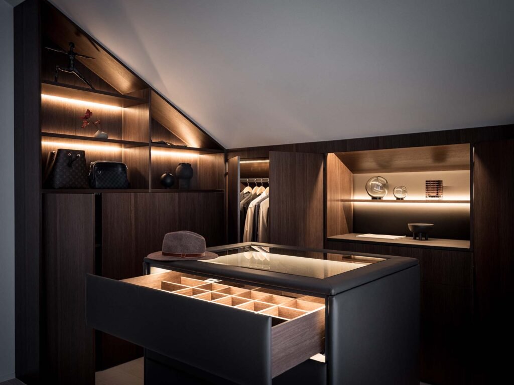 Stiligt - Den här svagt upplysta moderna klädkammaren är utformad med en stiligt touch och har trähyllor, en upplyst monter, hängande kläder och noggrant utvalda tillbehör.