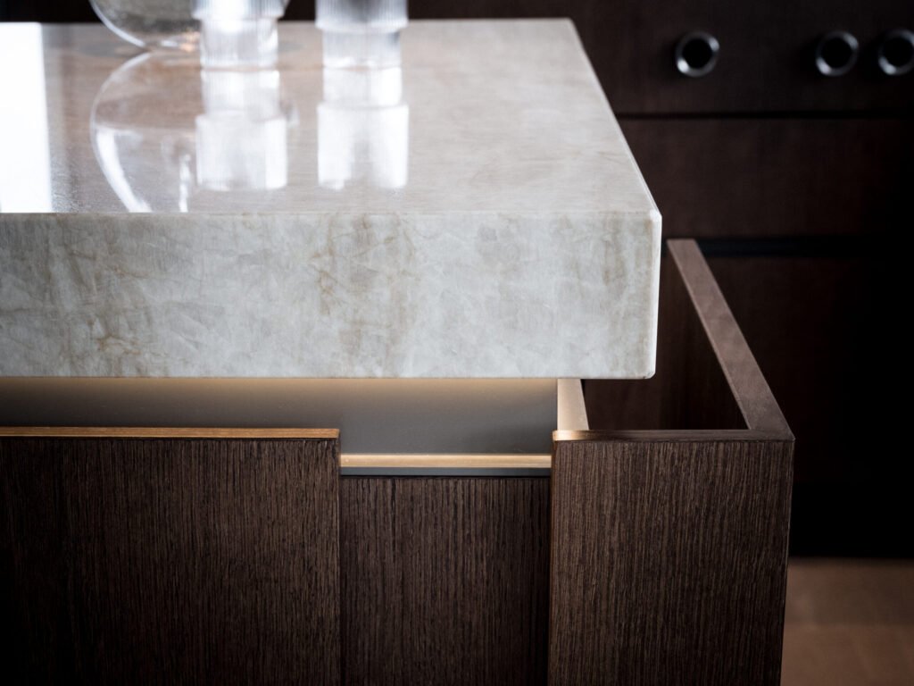 Stiligt - Närbild av en delvis öppen låda i mörkt trä under en elegant bänkskiva i ljus marmor med stiliga glasögon elegant arrangerade ovanpå.