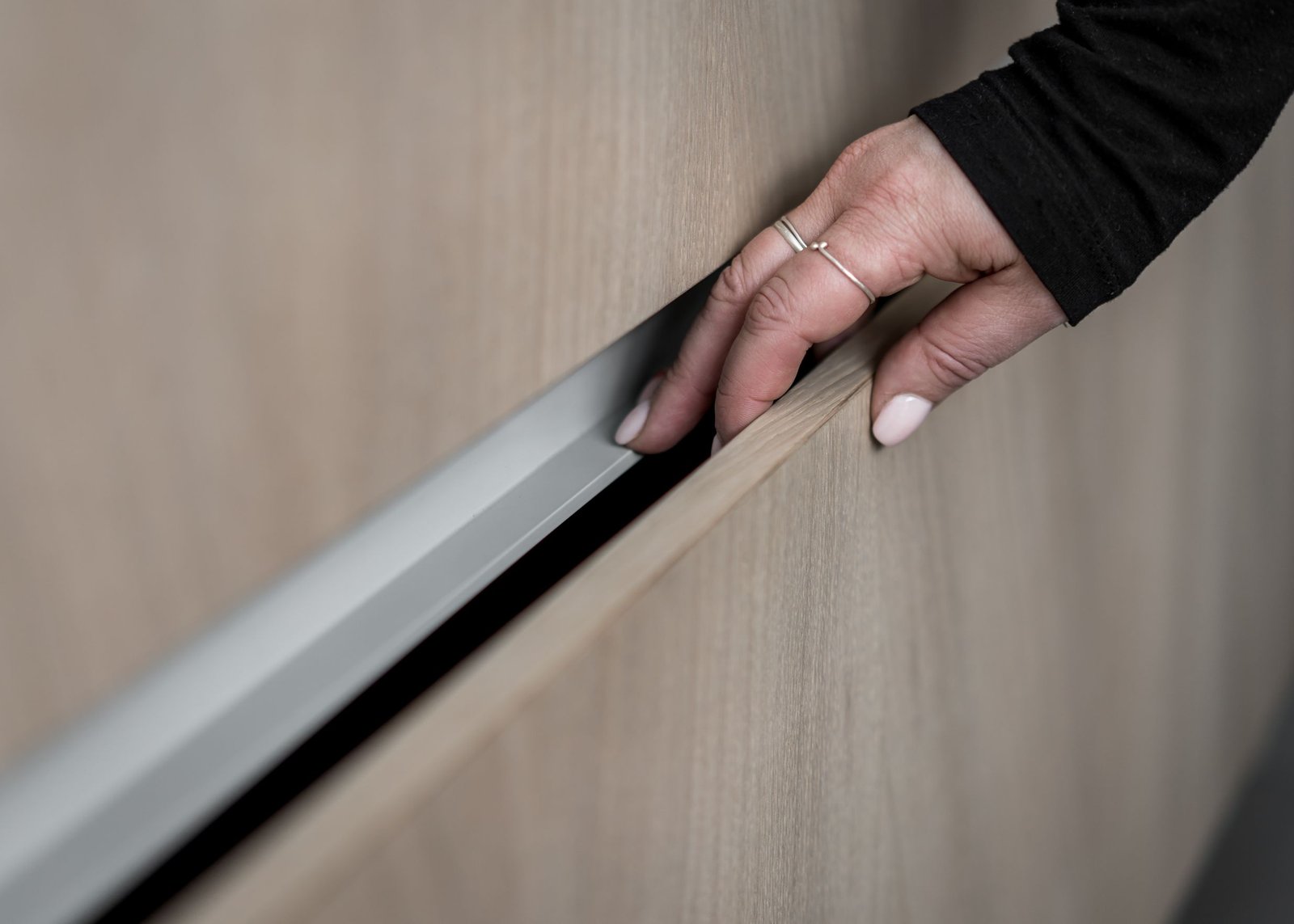 Stiligt - En hand med stiligt ring och välskötta naglar öppnar en trälåda något.