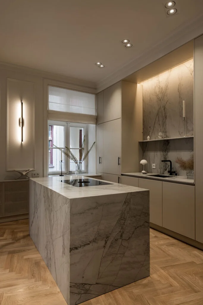 Stiligt - Modernt kök med beige skåp, marmorö och stänkskydd, inbyggda vitvaror och fiskbensparkett i trä - detta är ett av våra Vackra Moderna Kök, vackert upplyst av infälld belysning och väggbelysning. Vackra moderna kök: inspirerande design för ditt hem