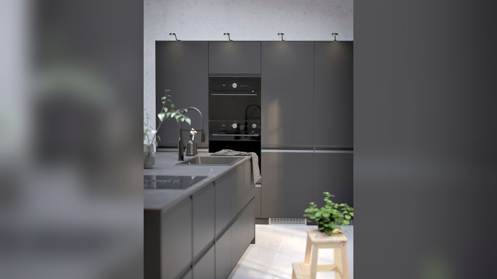 Stiligt - Modernt kök med matt mörka skåp, inbyggd ugn, svart diskho, krukväxter och en träpall på ett ljust golv.