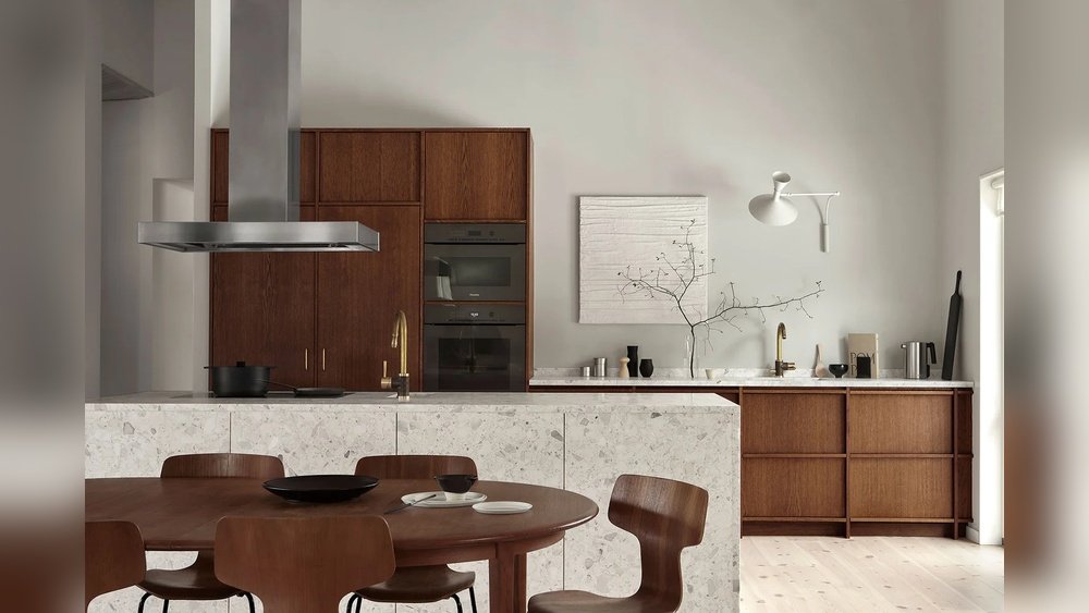 Stiligt - Modernt kök med skåp i mörkt trä, bänkskivor i marmor, inbyggda vitvaror, ett runt matbord med stolar och minimalistisk inredning mot ljusa väggar.