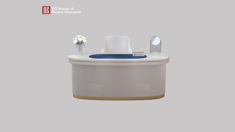 Stiligt - En modern vit receptionsdisk med blå inläggningar, en vit stol, en vas med vita blommor och en liten rund spegel på en ljusgrå bakgrund.