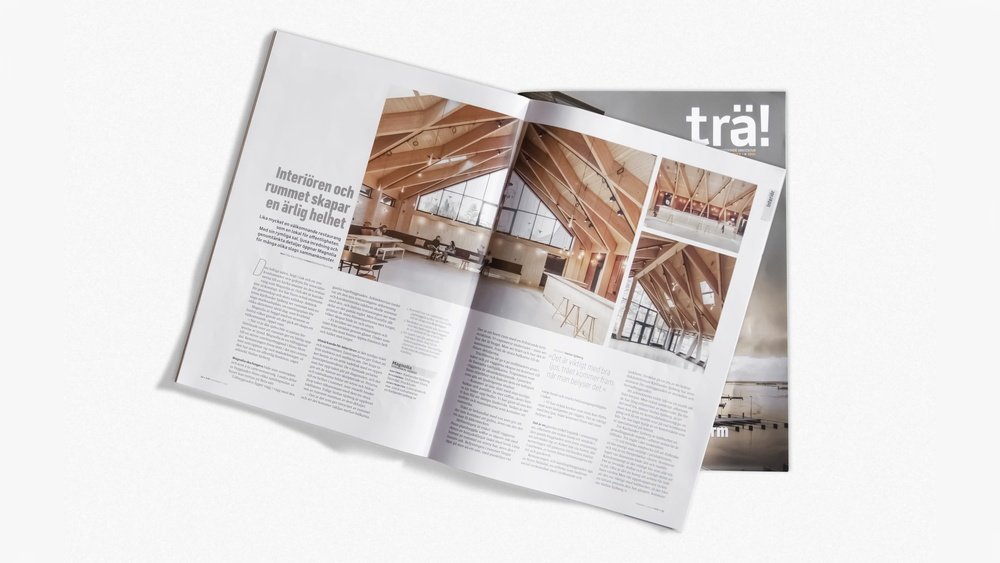 Stiligt - En öppen tidning med arkitekturbilder och text på svenska, placerad ovanpå en sluten tidning med titeln "trä!" mot en vit bakgrund.