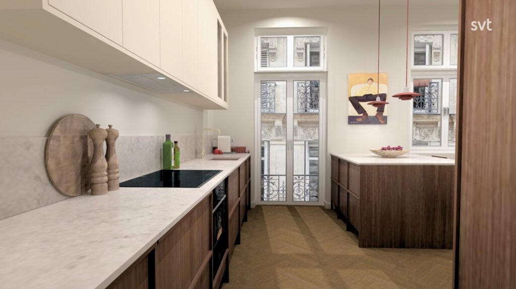 Stiligt - Modernt kök med skåp i trä, bänkskivor i marmor och inbyggd ugn; stora fönster ger naturligt ljus och en tavla hänger på väggen ovanför köksön.