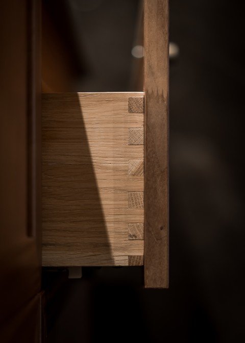 Stiligt - En närbild av en delvis öppen trälåda som visar svansfogarna på lådans sida – en elegant detalj som ofta återfinns i klassiska Shakerkök-design.