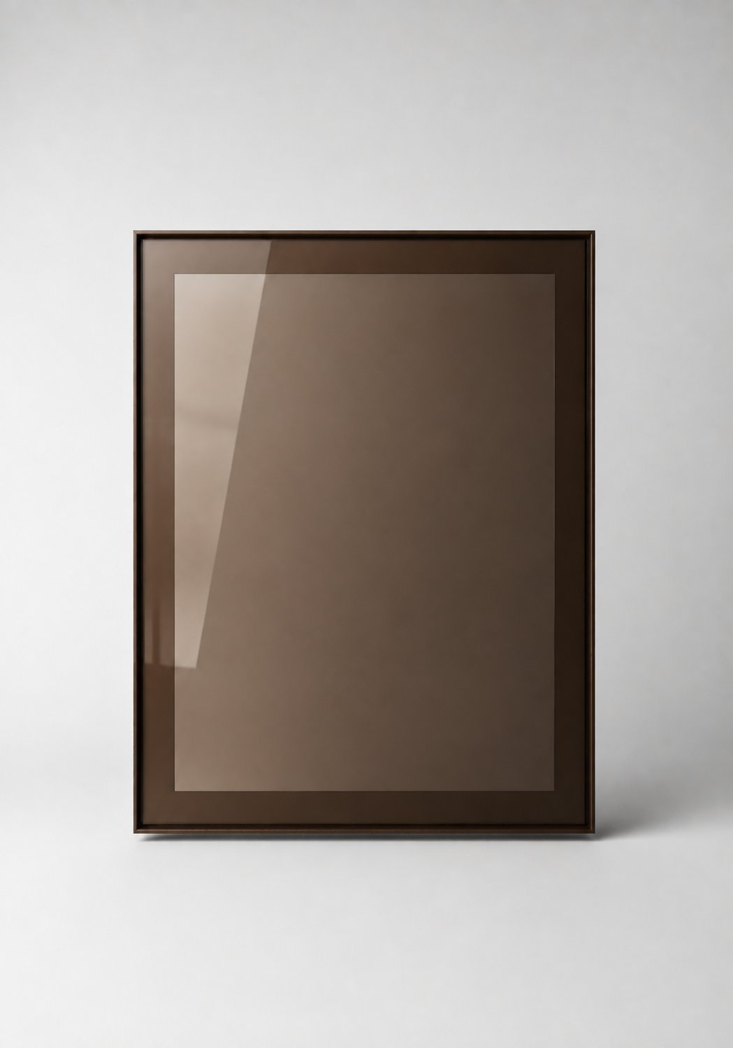 Stiligt - En tom, brun, rektangulär ram med en front av reflekterande glas som står upprätt mot en enfärgad, ljusgrå bakgrund.