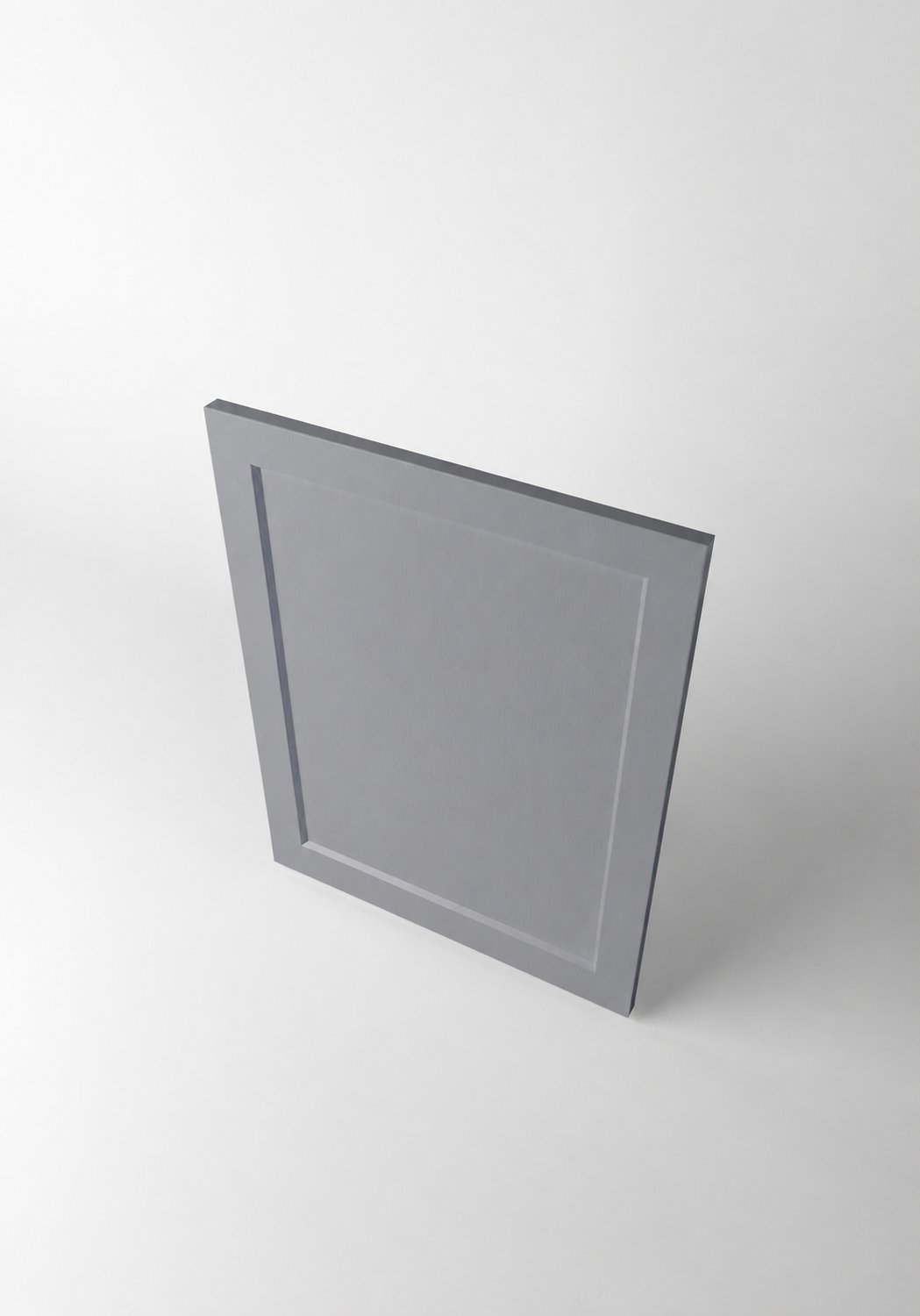 Stiligt - En ensam grå, fyrkantig skåpdörr med en infälld mittpanel avbildas stående upprätt mot en enfärgad vit bakgrund.