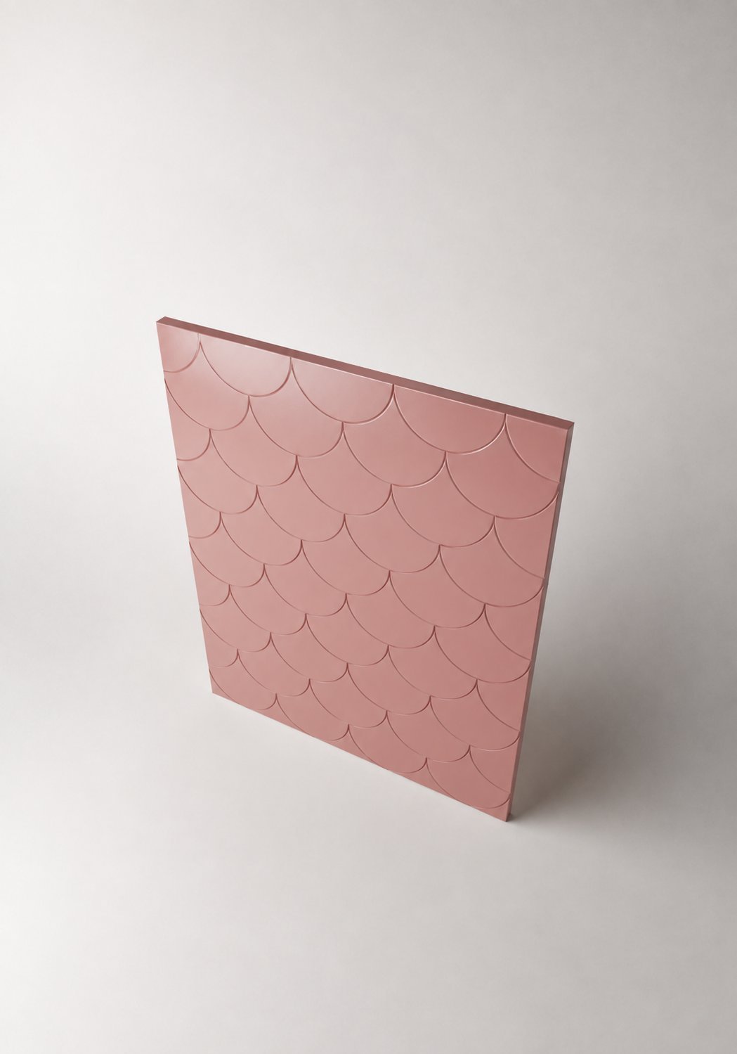 Stiligt - En rosa fyrkantig kakelpanel står upprätt och har ett upprepande vågigt mönster på ytan mot en neutral bakgrund.