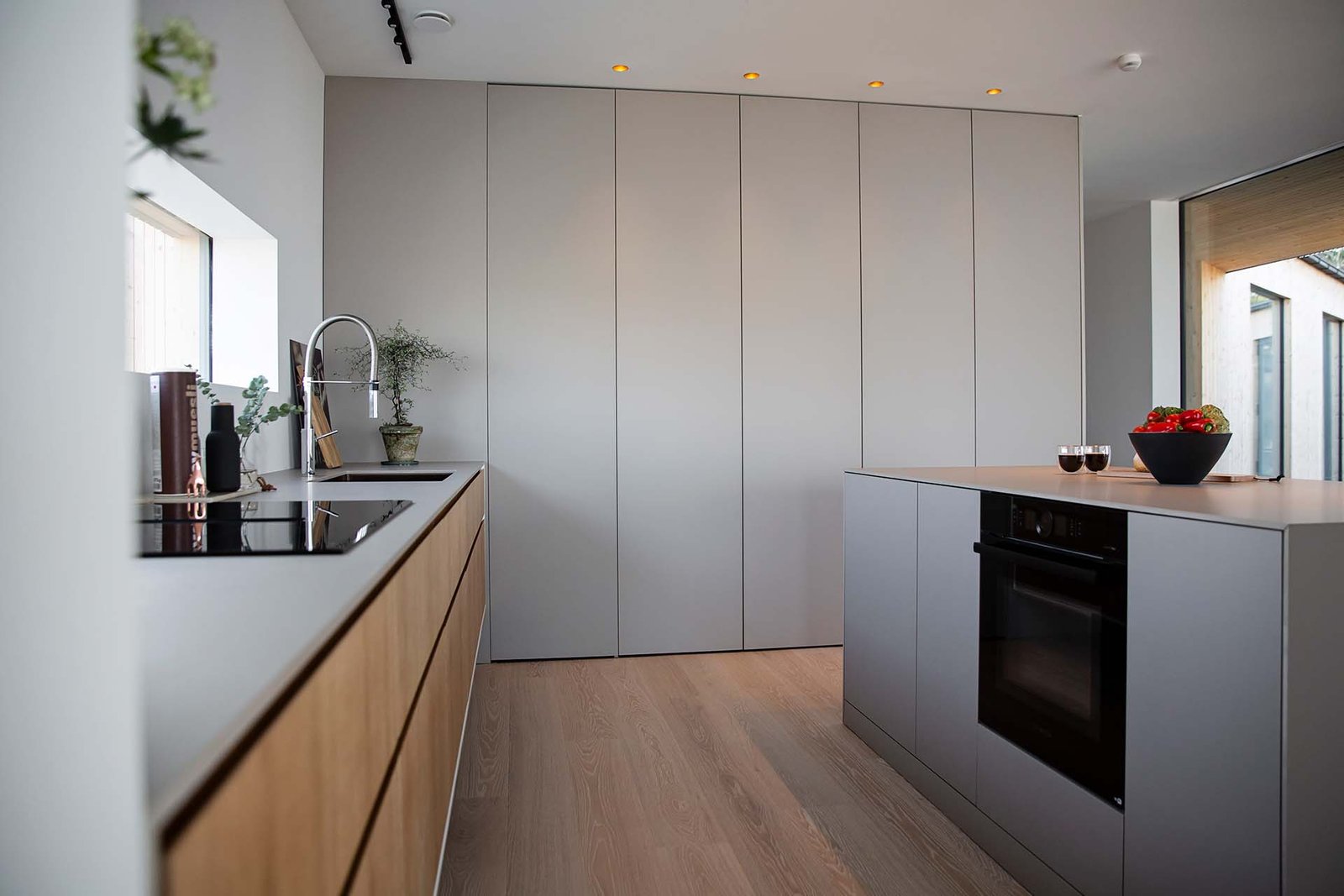 Minimalistiskt-kok-dold-forvaring-kok-danskt-Fenix-Arizona-beige-supermodular-vagghangda-skap-integrerad-flakt-hall-bosch-platsbyggt-kok-mattanpassat.jpg