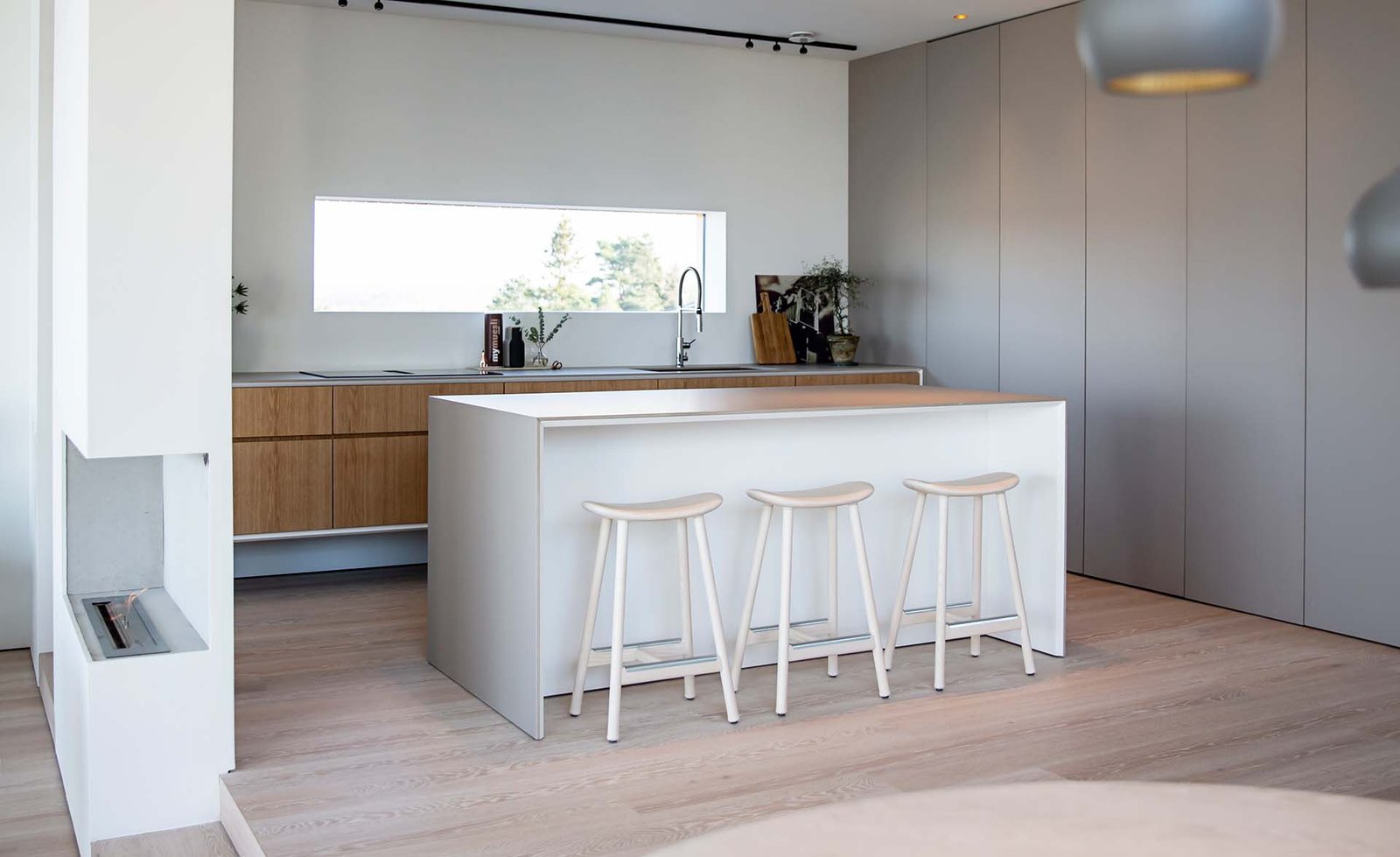 minimalistiskt-kok-skandinaviskt-exklusivt-platsbyggt-kokso-oppen-planlosning-barstolar-ekfaner-slata-luckor-arizone-beige-bankskiva-tapwell-supermodular.jpg